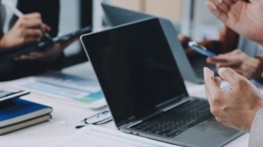 İş ekibi dizüstü bilgisayarda çalışıyor ve fikirleri tartışıyor.