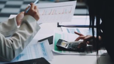 İş yerinde dizüstü bilgisayar ve hesap makinesi kullanan iş kadını