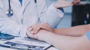 Steteskoplu doktor el ele tutuşuyor.