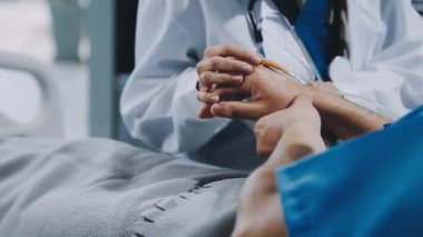 Üniformalı bir doktorun klinikte hastayla el ele tutuşması. Sağlık ve sağlık sigortası kavramı.