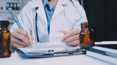 Beyaz önlüklü doktor ilaç tutuyor.