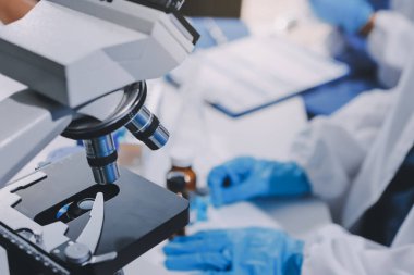 Laboratuvarda mikroskop kullanan bir bilim adamı. Laboratuvar ortamında modern bir mikroskobu ayarlayan bir araştırmacının ellerine yakın çekim. Bilim konsepti