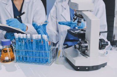 Laboratuvarda mikroskop kullanan bir bilim adamı. Laboratuvar ortamında modern bir mikroskobu ayarlayan bir araştırmacının ellerine yakın çekim. Bilim konsepti