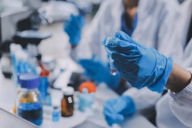 Laboratuvarda mikroskop kullanan bir bilim adamı. Laboratuvar ortamında modern bir mikroskobu ayarlayan bir araştırmacının ellerine yakın çekim. Bilim konsepti