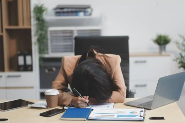 Yorgun ve Asyalı bir kadının portresi ofiste vergi bilgisayarıyla çalışıyor. Üzgün, mutsuz, endişeli, depresyon ya da çalışan hayatı stres konsepti