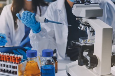 Laboratuvarda mikroskop kullanan bir bilim adamı. Laboratuvar ortamında modern bir mikroskobu ayarlayan bir araştırmacının ellerine yakın çekim. Bilim konsepti