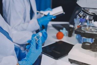 Laboratuvarda mikroskop kullanan bir bilim adamı. Laboratuvar ortamında modern bir mikroskobu ayarlayan bir araştırmacının ellerine yakın çekim. Bilim konsepti