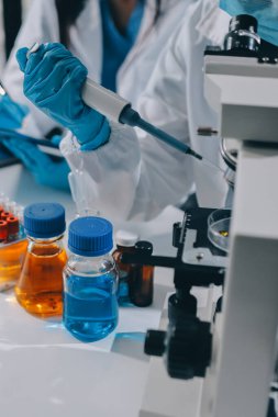 Laboratuvarda mikroskop kullanan bir bilim adamı. Laboratuvar ortamında modern bir mikroskobu ayarlayan bir araştırmacının ellerine yakın çekim. Bilim konsepti