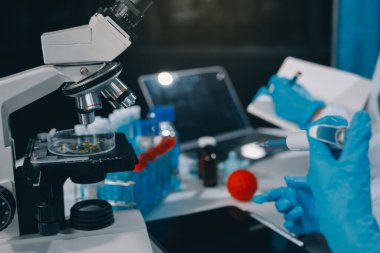 Laboratuvarda mikroskop kullanan bir bilim adamı. Laboratuvar ortamında modern bir mikroskobu ayarlayan bir araştırmacının ellerine yakın çekim. Bilim konsepti