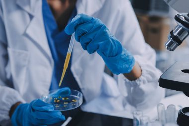 Laboratuvarda mikroskop kullanan bir bilim adamı. Laboratuvar ortamında modern bir mikroskobu ayarlayan bir araştırmacının ellerine yakın çekim. Bilim konsepti