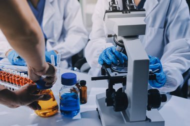 Laboratuvarda mikroskop kullanan bir bilim adamı. Laboratuvar ortamında modern bir mikroskobu ayarlayan bir araştırmacının ellerine yakın çekim. Bilim konsepti