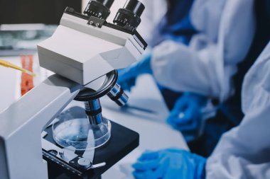 Laboratuvarda mikroskop kullanan bir bilim adamı. Laboratuvar ortamında modern bir mikroskobu ayarlayan bir araştırmacının ellerine yakın çekim. Bilim konsepti
