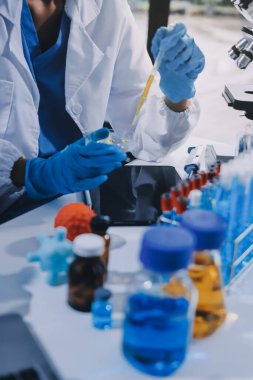 Laboratuvarda mikroskop kullanan bir bilim adamı. Laboratuvar ortamında modern bir mikroskobu ayarlayan bir araştırmacının ellerine yakın çekim. Bilim konsepti