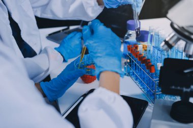 Laboratuvarda mikroskop kullanan bir bilim adamı. Laboratuvar ortamında modern bir mikroskobu ayarlayan bir araştırmacının ellerine yakın çekim. Bilim konsepti