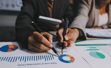 İş adamlarından oluşan bir ekip, pazarlama planı, piyasa araştırma raporları ve gelir istatistikleri, Mali ve Muhasebe kavramının verilerini analiz etmek üzere toplanıyor..