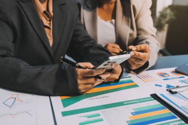 İş adamlarından oluşan bir ekip, pazarlama planı, piyasa araştırma raporları ve gelir istatistikleri, Mali ve Muhasebe kavramının verilerini analiz etmek üzere toplanıyor..