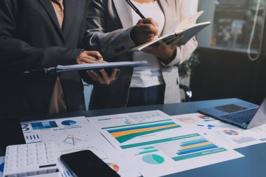 İş adamlarından oluşan bir ekip, pazarlama planı, piyasa araştırma raporları ve gelir istatistikleri, Mali ve Muhasebe kavramının verilerini analiz etmek üzere toplanıyor..