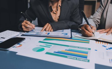 İş adamlarından oluşan bir ekip, pazarlama planı, piyasa araştırma raporları ve gelir istatistikleri, Mali ve Muhasebe kavramının verilerini analiz etmek üzere toplanıyor..