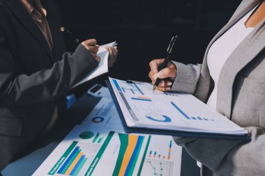 İş adamlarından oluşan bir ekip, pazarlama planı, piyasa araştırma raporları ve gelir istatistikleri, Mali ve Muhasebe kavramının verilerini analiz etmek üzere toplanıyor..