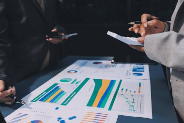 İş adamlarından oluşan bir ekip, pazarlama planı, piyasa araştırma raporları ve gelir istatistikleri, Mali ve Muhasebe kavramının verilerini analiz etmek üzere toplanıyor..