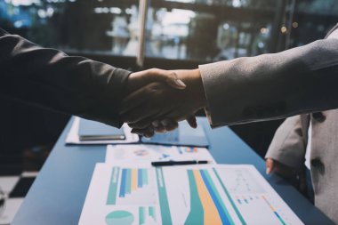 Başarılı bir müzakere olarak tokalaşma, yakın plan. Modern ofiste kontrat imzaladıktan sonra bilinmeyen iş adamları el sıkışıyor