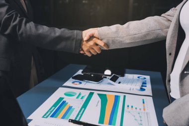 Başarılı bir müzakere olarak tokalaşma, yakın plan. Modern ofiste kontrat imzaladıktan sonra bilinmeyen iş adamları el sıkışıyor