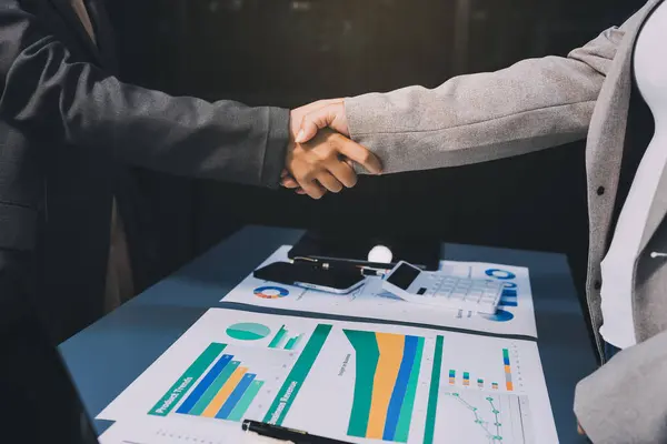 Handshake as successful negotiation ending, close-up. Unknown business people shaking hands after contract signing in modern office