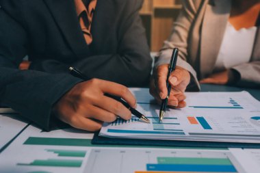 İş adamlarından oluşan bir ekip, pazarlama planı, piyasa araştırma raporları ve gelir istatistikleri, Mali ve Muhasebe kavramının verilerini analiz etmek üzere toplanıyor..