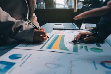 İş adamlarından oluşan bir ekip, pazarlama planı, piyasa araştırma raporları ve gelir istatistikleri, Mali ve Muhasebe kavramının verilerini analiz etmek üzere toplanıyor..