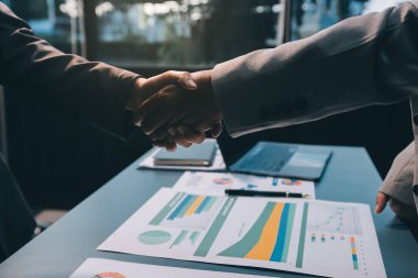 Başarılı bir müzakere olarak tokalaşma, yakın plan. Modern ofiste kontrat imzaladıktan sonra bilinmeyen iş adamları el sıkışıyor