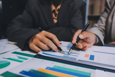 İş adamlarından oluşan bir ekip, pazarlama planı, piyasa araştırma raporları ve gelir istatistikleri, Mali ve Muhasebe kavramının verilerini analiz etmek üzere toplanıyor..