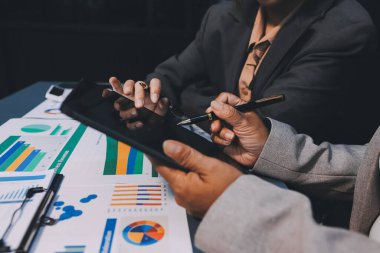 İş adamlarından oluşan bir ekip, pazarlama planı, piyasa araştırma raporları ve gelir istatistikleri, Mali ve Muhasebe kavramının verilerini analiz etmek üzere toplanıyor..