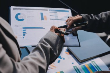 İş adamlarından oluşan bir ekip, pazarlama planı, piyasa araştırma raporları ve gelir istatistikleri, Mali ve Muhasebe kavramının verilerini analiz etmek üzere toplanıyor..