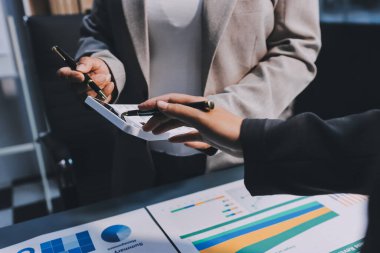 İş adamlarından oluşan bir ekip, pazarlama planı, piyasa araştırma raporları ve gelir istatistikleri, Mali ve Muhasebe kavramının verilerini analiz etmek üzere toplanıyor..