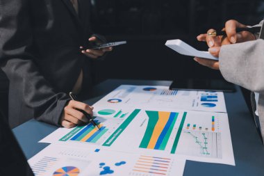 İş adamlarından oluşan bir ekip, pazarlama planı, piyasa araştırma raporları ve gelir istatistikleri, Mali ve Muhasebe kavramının verilerini analiz etmek üzere toplanıyor..