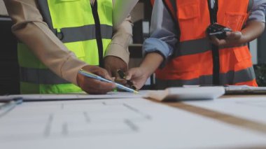 İşyerindeki şantiyede çalışan mühendis veya inşaat işçisi.