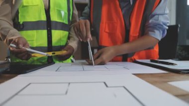 Arkaplanda inşaat alanı olan bir proje üzerinde çalışan mühendis.