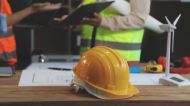 İş yerinde sarı kasklı, kasklı ve planlı mühendis mühendis. inşaat kavramı