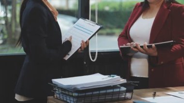 Takım elbiseli genç Asyalı iş kadını ofiste sözleşme imzalıyor.