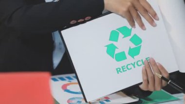 Elinde geri dönüşüm işareti olan kağıt tutan kadın.