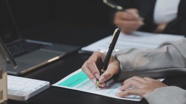 İşadamı ofisinde kağıt üzerine el yazısı yazıyor.