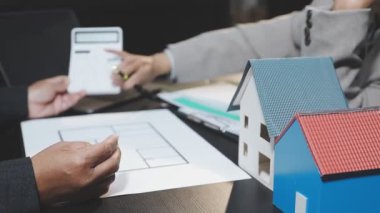 Emlakçı bir ev almak için müşteri evini tartışıyor. Sigorta acentesi veya müşteri sigorta acentesi ve ev formu.