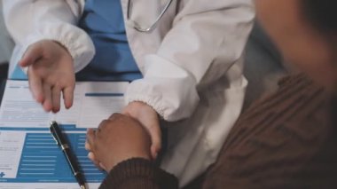 Doktor elinde kalem ve hasta tutuyor.