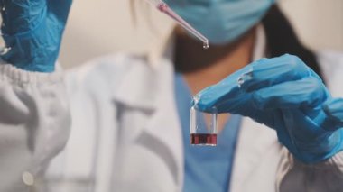 Laboratuvarda deney tüpleri olan koruyucu kıyafetli bir bilim adamı.