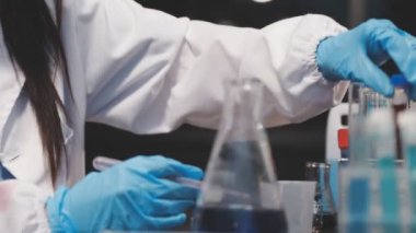 Laboratuvarda koruyucu eldivenleri olan bilim adamı.