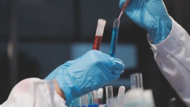 Bilim adamının elinde kan örneğiyle test tüpü tutarken yakın plan fotoğrafı..