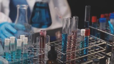 Laboratuvardaki laboratuvar asistanı. Kimya konsepti. Laboratuvar asistanı tüplerdeki kimyasal testler üzerinde çalışıyor. Kapat - kapat