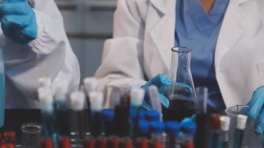 Yakın plan - Laboratuvarda test tüpünü sıvı ile tutan bilim adamının fotoğrafı