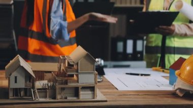 Ofiste ev planı üzerinde çalışan mimar ya da mühendis. Emlak işi konsepti. İnşaat alanında miğferi olan mühendis.