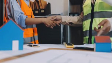 Mühendis ve mühendisin iş yerindeki, inşaat alanındaki, mühendislik ve mühendislik alanındaki müşterilere el sıkışması